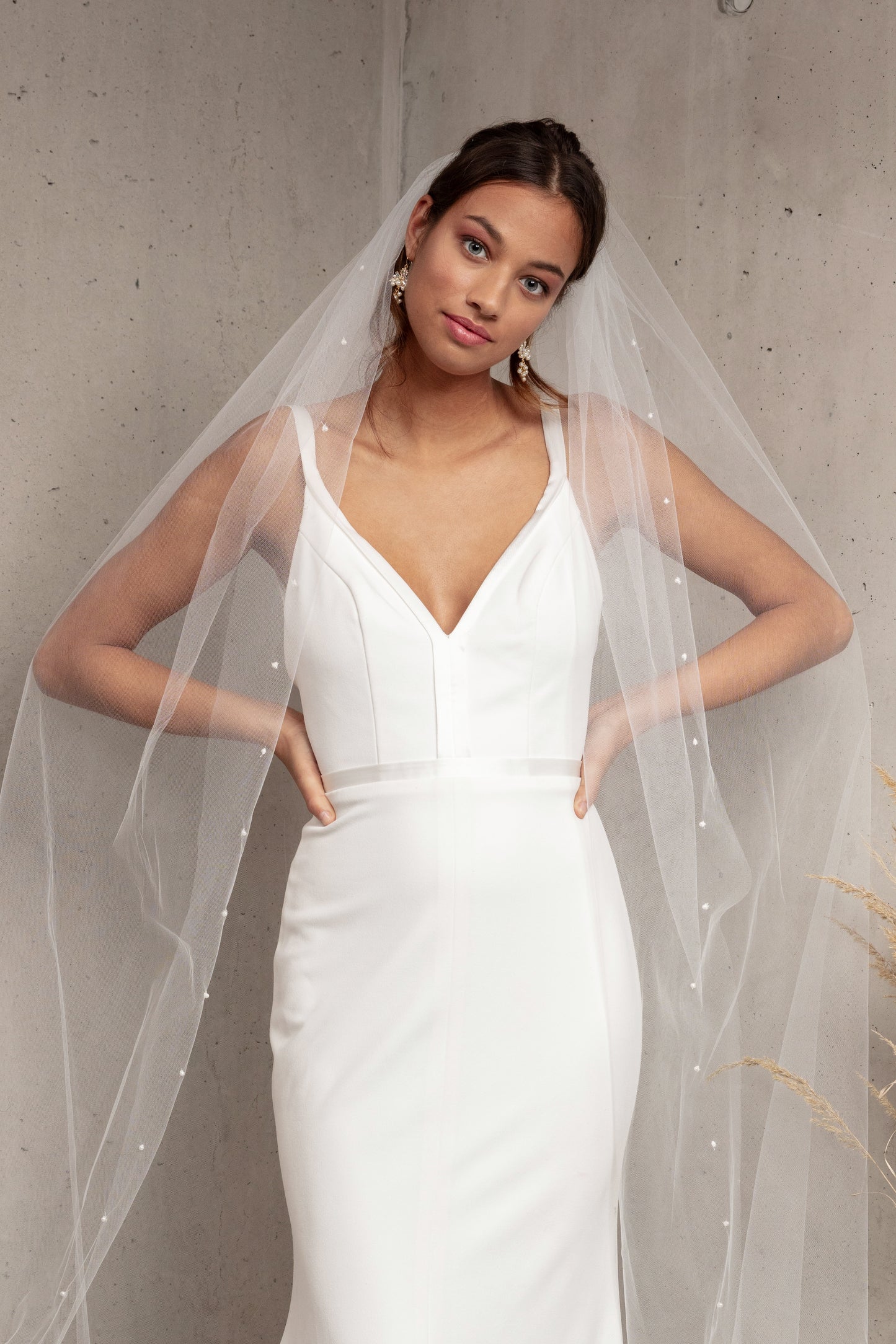 Complete your wedding look with our simply elegant MAJA VEIL. This classic piece features a delicately placed pearl edge in a linear pattern finished with voluminous gathering at the crown. Make a statement in the popular cathedral length or choose from shoulder, elbow, fingertip, floor, chapel, and royal lengths..