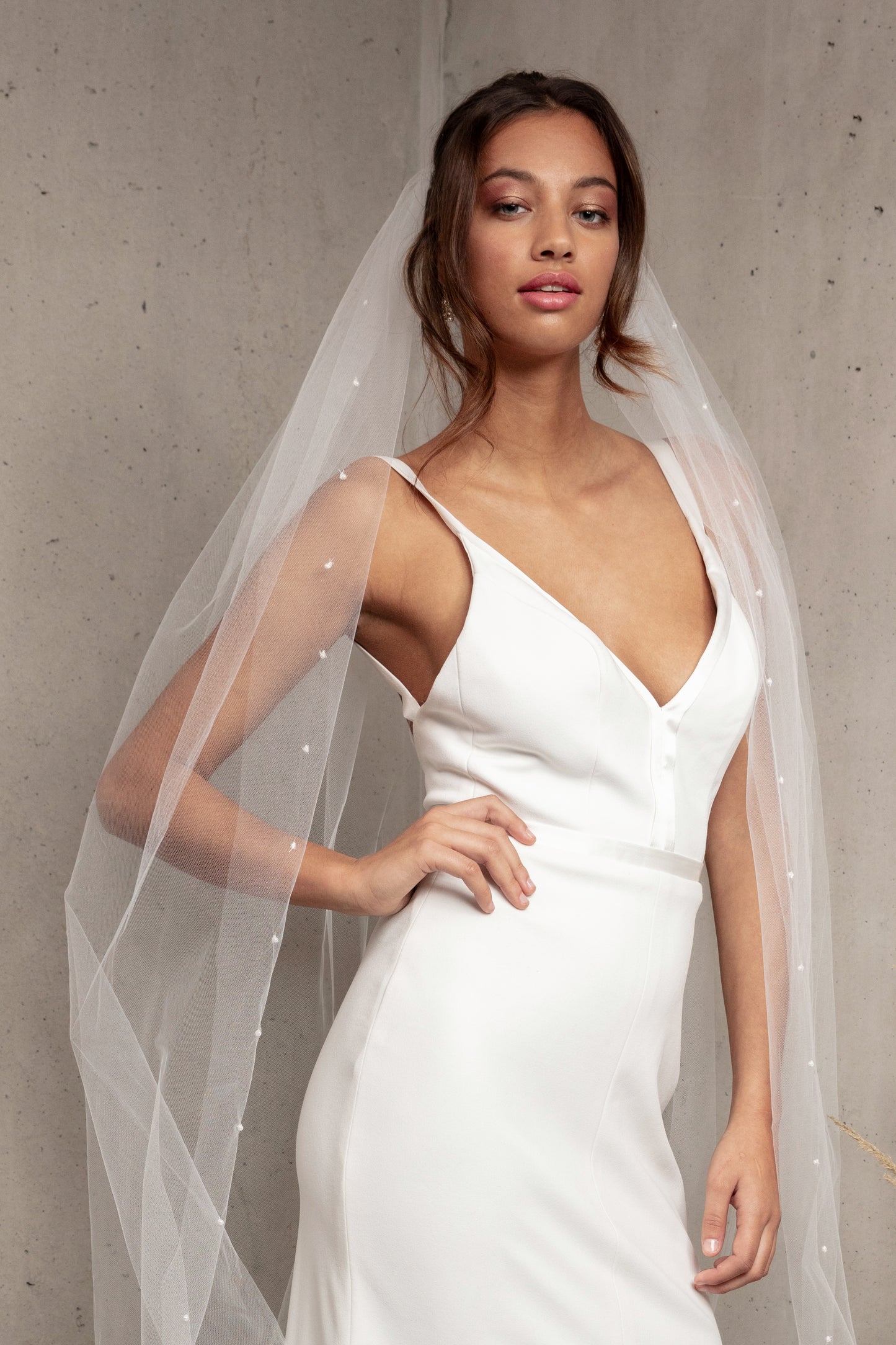 Complete your wedding look with our simply elegant MAJA VEIL. This classic piece features a delicately placed pearl edge in a linear pattern finished with voluminous gathering at the crown. Make a statement in the popular cathedral length or choose from shoulder, elbow, fingertip, floor, chapel, and royal lengths..