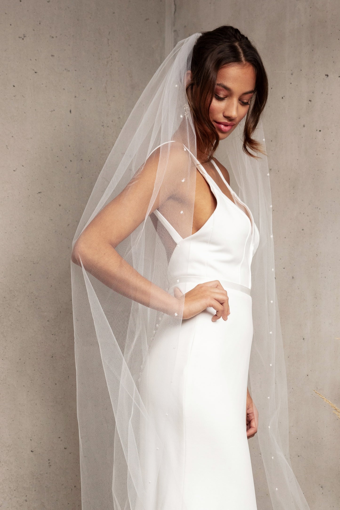 Complete your wedding look with our simply elegant MAJA VEIL. This classic piece features a delicately placed pearl edge in a linear pattern finished with voluminous gathering at the crown. Make a statement in the popular cathedral length or choose from shoulder, elbow, fingertip, floor, chapel, and royal lengths..