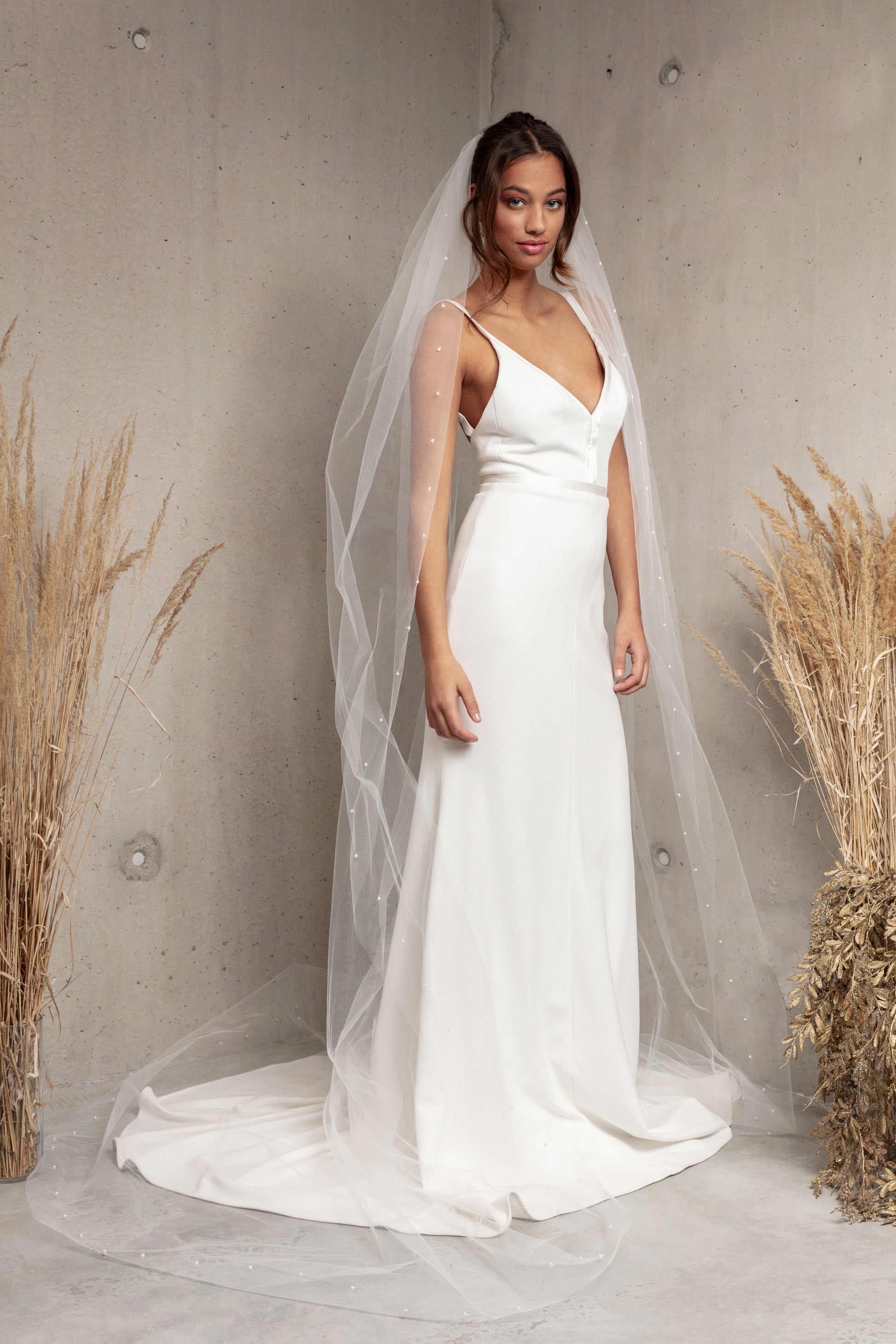 Complete your wedding look with our simply elegant MAJA VEIL. This classic piece features a delicately placed pearl edge in a linear pattern finished with voluminous gathering at the crown. Make a statement in the popular cathedral length or choose from shoulder, elbow, fingertip, floor, chapel, and royal lengths..