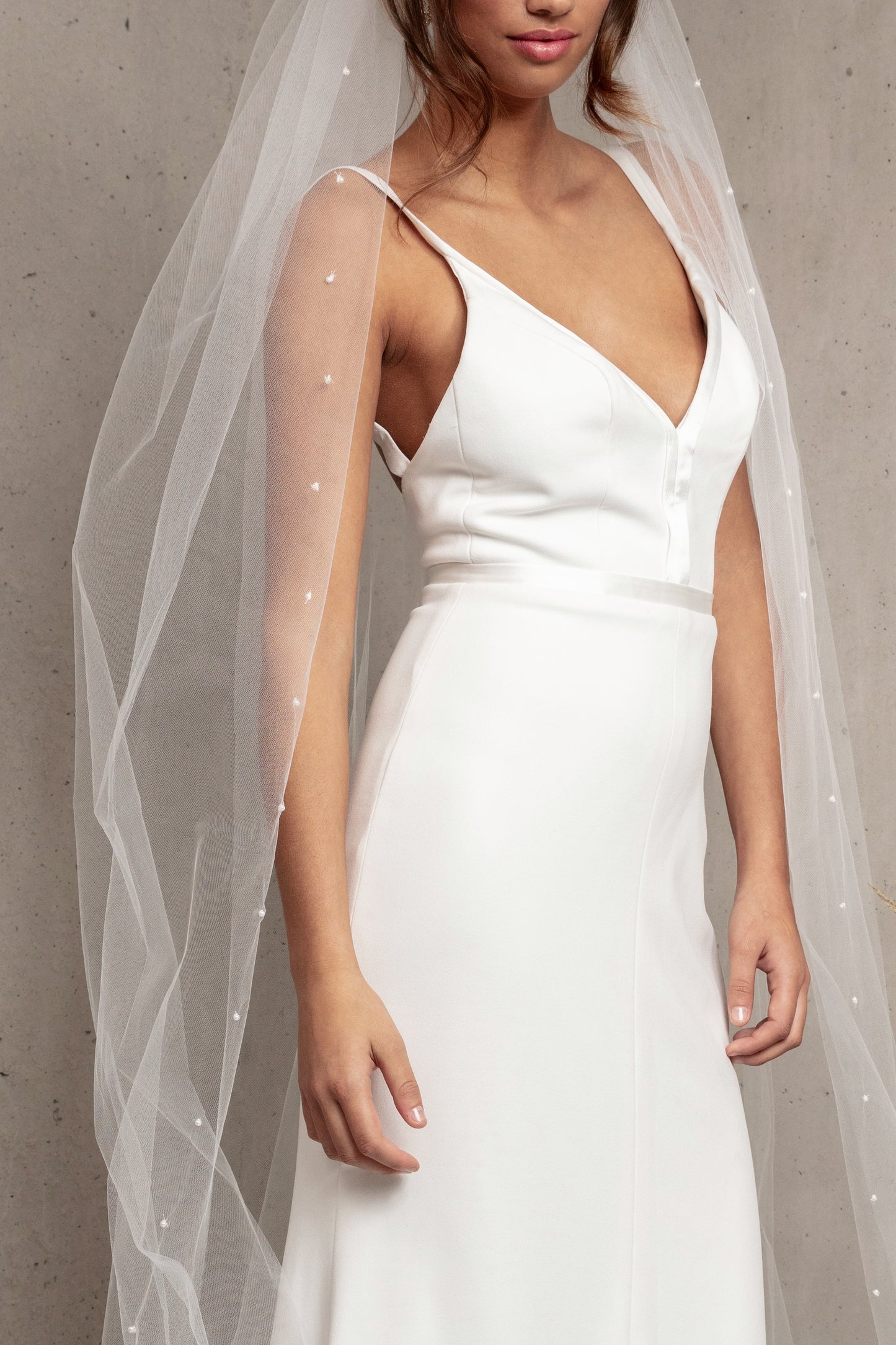 Complete your wedding look with our simply elegant MAJA VEIL. This classic piece features a delicately placed pearl edge in a linear pattern finished with voluminous gathering at the crown. Make a statement in the popular cathedral length or choose from shoulder, elbow, fingertip, floor, chapel, and royal lengths..
